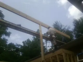 Carpenter setting a ridge beam over a new addition frame — Ice Dam Removal by Roofing Brothers in Bloomingdale