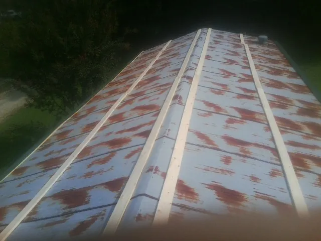 Rusted metal roof panels with new wood purlins before replacement — Storm Damage Roof Repair in Bloomingdale by Roofing Brothers